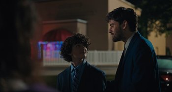 Two men in suits talking to each other outside