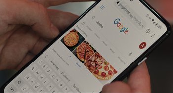 Movie still from “Cha Cha Real Smooth” (2022), directed by Cooper Raiff – A person is looking at a pizza menu on a cell phone; Extreme Close Up shot, High angle