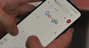 Movie still from “Cha Cha Real Smooth” (2022), directed by Cooper Raiff – A person is looking at the google homepage on a cell phone; Extreme Close Up shot, High angle