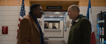 Movie still from “Champions” (2023), directed by Bobby Farrelly – Two men standing next to each other in front of a building; Medium shot, Over the shoulder angle