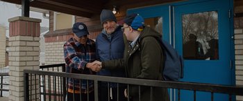 Movie still from “Champions” (2023), directed by Bobby Farrelly – A group of men standing next to each other on a bridge; Medium shot, Over the shoulder angle