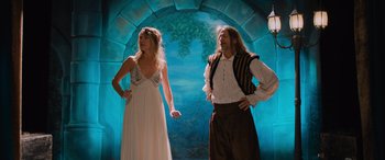 Movie still from “Champions” (2023), directed by Bobby Farrelly – A man and a woman standing next to each other in front of an archway; Wide shot, Low angle