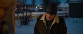 Movie still from “Champions” (2023), directed by Bobby Farrelly – A man wearing a winter coat and a hat in the snow at night; Medium shot, Over the shoulder angle