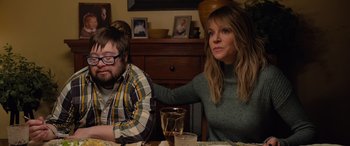 Movie still from “Champions” (2023), directed by Bobby Farrelly – A woman sitting at a table next to a young man; Medium shot, Over the shoulder angle