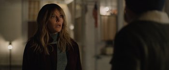 Movie still from “Champions” (2023), directed by Bobby Farrelly – A woman standing in a room with lights in the background; Medium shot, Over the shoulder angle