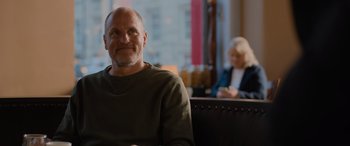 Movie still from “Champions” (2023), directed by Bobby Farrelly – A man sitting in front of a woman in a room; Medium shot, Over the shoulder angle