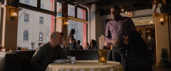 Movie still from “Champions” (2023), directed by Bobby Farrelly – Two men sitting at a table in a restaurant; Medium shot, Over the shoulder angle