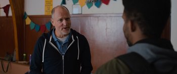 Movie still from “Champions” (2023), directed by Bobby Farrelly – A man talking to another man in front of a wall; Medium shot, Over the shoulder angle