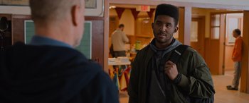 Movie still from “Champions” (2023), directed by Bobby Farrelly – A man standing next to another man in front of a table; Close Up shot, Over the shoulder angle