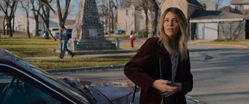 Movie still from “Champions” (2023), directed by Bobby Farrelly – A woman standing in front of a car on a city street; Medium shot, Over the shoulder angle