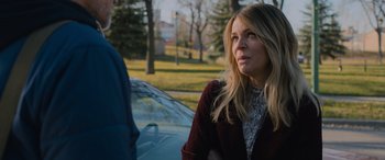 Movie still from “Champions” (2023), directed by Bobby Farrelly – A woman standing in front of a car on a street; Close Up shot, Over the shoulder angle