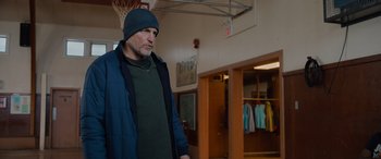 Movie still from “Champions” (2023), directed by Bobby Farrelly – A man wearing a hat and a blue jacket; Medium shot, Over the shoulder angle