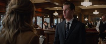 Movie still from “Champions” (2023), directed by Bobby Farrelly – A man in a business suit talking to a woman in a suit; Close Up shot, Over the shoulder angle