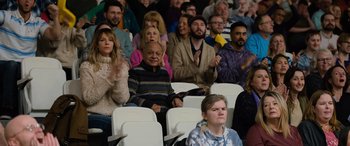 Movie still from “Champions” (2023), directed by Bobby Farrelly – A group of people sitting in a row of seats; Medium shot, High angle