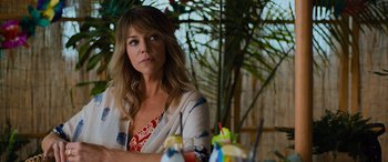 Movie still from “Champions” (2023), directed by Bobby Farrelly – A woman sitting in front of a table with drinks on it; Close Up shot, Over the shoulder angle