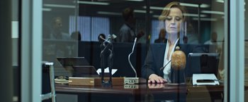 Movie still from “Chappie” (2015), directed by Neill Blomkamp – A woman sitting at a desk in front of a computer; Medium shot, Over the shoulder angle