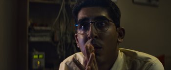 Movie still from “Chappie” (2015), directed by Neill Blomkamp – A man with glasses is eating a piece of food; Close Up shot, Low angle