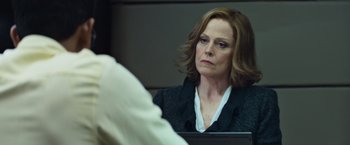 Movie still from “Chappie” (2015), directed by Neill Blomkamp – A woman sitting in front of a mirror looking at herself in the mirror; Close Up shot, Over the shoulder angle