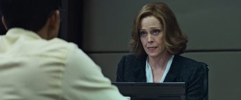 Movie still from “Chappie” (2015), directed by Neill Blomkamp – A woman sitting in front of a computer screen; Close Up shot, Over the shoulder angle