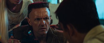 Movie still from “Chappie” (2015), directed by Neill Blomkamp – A man with an angry look on his face; Close Up shot, Over the shoulder angle