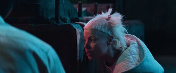 Movie still from “Chappie” (2015), directed by Neill Blomkamp – A woman with white hair looking over a wall; Close Up shot, Low angle