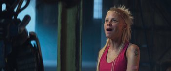 Movie still from “Chappie” (2015), directed by Neill Blomkamp – A woman with blonde hair is standing in a room; Close Up shot, Low angle