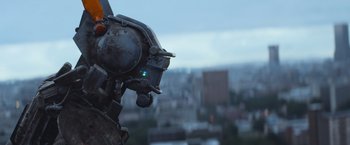 Movie still from “Chappie” (2015), directed by Neill Blomkamp – View of a metal object with a city in the background; Close Up shot, Low angle