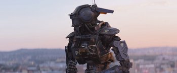 Movie still from “Chappie” (2015), directed by Neill Blomkamp – A robot with a sky in the background; Medium shot, Low angle