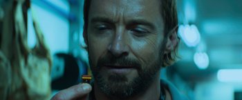 Movie still from “Chappie” (2015), directed by Neill Blomkamp – A person holding a pill; Close Up shot, Over the shoulder angle