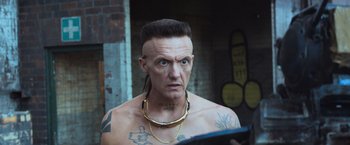 Movie still from “Chappie” (2015), directed by Neill Blomkamp – A man with tattoos on his head and neck; Close Up shot, Over the shoulder angle
