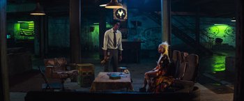 Movie still from “Chappie” (2015), directed by Neill Blomkamp – A man and a woman sitting in a room; Wide shot, High angle