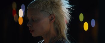 Movie still from “Chappie” (2015), directed by Neill Blomkamp – A woman with a mohawk is looking to the side; Close Up shot, Low angle