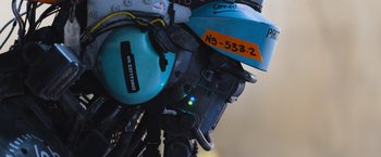 Movie still from “Chappie” (2015), directed by Neill Blomkamp – View of a blue helmet and ear muffs; Extreme Close Up shot, Over the shoulder angle