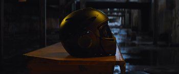 Movie still from “Chappie” (2015), directed by Neill Blomkamp – A motorcycle helmet sitting on top of a wooden table; Close Up shot, High angle
