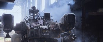 Movie still from “Chappie” (2015), directed by Neill Blomkamp – An old train engine with smoke coming out of it; Extreme Wide shot, High angle