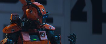 Movie still from “Chappie” (2015), directed by Neill Blomkamp – A red robot's face and hands; Close Up shot, Low angle