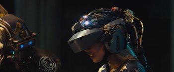 Movie still from “Chappie” (2015), directed by Neill Blomkamp – A person wearing a helmet with headphones on it; Close Up shot, Over the shoulder angle