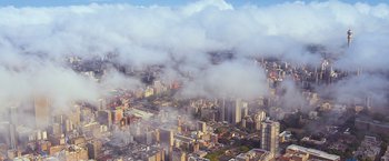 Movie still from “Chappie” (2015), directed by Neill Blomkamp – An aerial view of a large city in the middle of the day; Extreme Wide shot, High angle