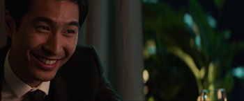Movie still from “Charlie's Angels” (2019), directed by Elizabeth Banks – A man sitting in front of a window with trees in the background; Close Up shot, Over the shoulder angle