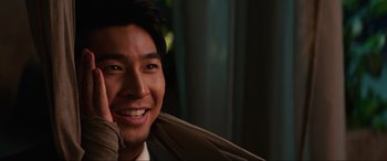 Movie still from “Charlie's Angels” (2019), directed by Elizabeth Banks – A person wearing a suit and smiling; Close Up shot, Over the shoulder angle