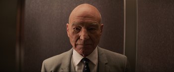 Movie still from “Charlie's Angels” (2019), directed by Elizabeth Banks – An older man wearing a suit and tie; Close Up shot, Low angle