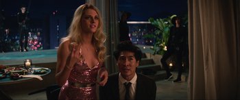 Movie still from “Charlie's Angels” (2019), directed by Elizabeth Banks – A man and a woman are standing next to each other in front of a building; Medium shot, Over the shoulder angle