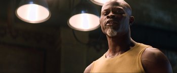 Movie still from “Charlie's Angels” (2019), directed by Elizabeth Banks – An older man with a beard is looking at the camera; Close Up shot, Low angle