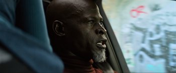 Movie still from “Charlie's Angels” (2019), directed by Elizabeth Banks – A man with a beard sitting in a car looking out the window; Close Up shot, Low angle