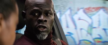 Movie still from “Charlie's Angels” (2019), directed by Elizabeth Banks – A man with a beard and a red shirt is sitting in a car; Close Up shot, Low angle