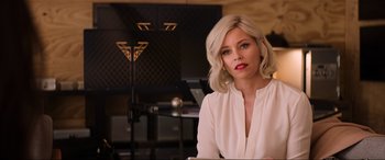Movie still from “Charlie's Angels” (2019), directed by Elizabeth Banks – A woman with blonde hair sitting at a table in front of a piano; Close Up shot, Over the shoulder angle