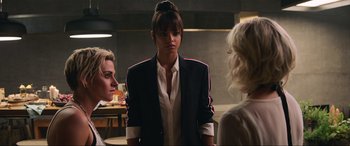Movie still from “Charlie's Angels” (2019), directed by Elizabeth Banks – A woman wearing a suit standing in front of two other women; Medium shot, Over the shoulder angle