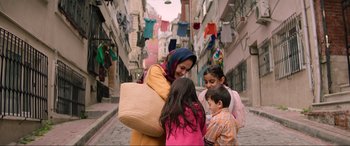 Movie still from “Charlie's Angels” (2019), directed by Elizabeth Banks – A group of people standing on the side of a street; Medium shot, Over the shoulder angle