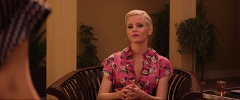 Movie still from “Charlie's Angels” (2019), directed by Elizabeth Banks – A woman sitting in a chair wearing a pink shirt; Medium shot, Over the shoulder angle