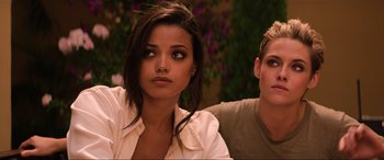 Movie still from “Charlie's Angels” (2019), directed by Elizabeth Banks – A woman sitting next to a man in front of flowers; Close Up shot, Over the shoulder angle